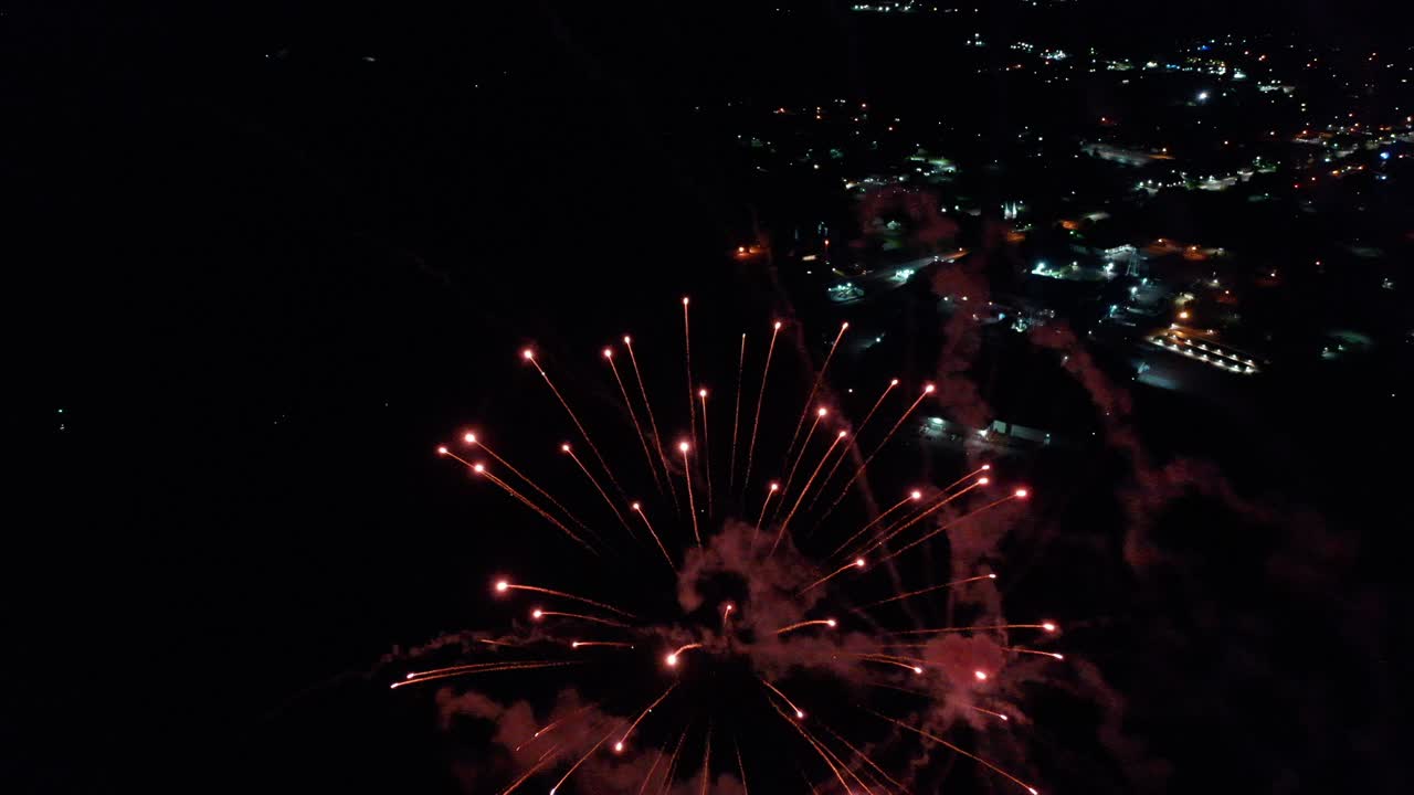 fuegos artificiales sobre una pequeña ciudad por la noche