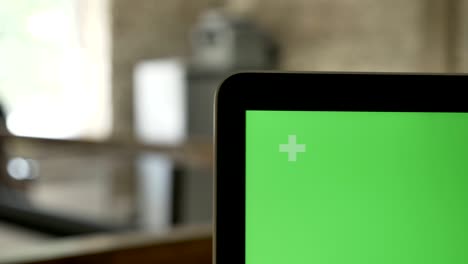 close shot of laptop's display with chroma key, office background