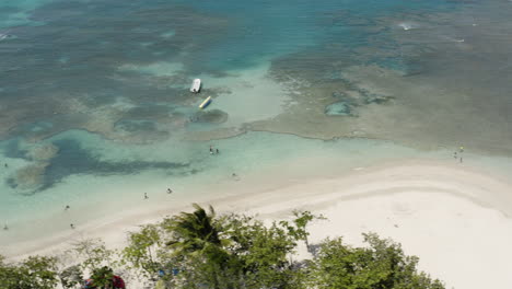 people enjoying water sports and summer swimming in playa teco maimon beach in puerto plata dominican republic - aerial shot