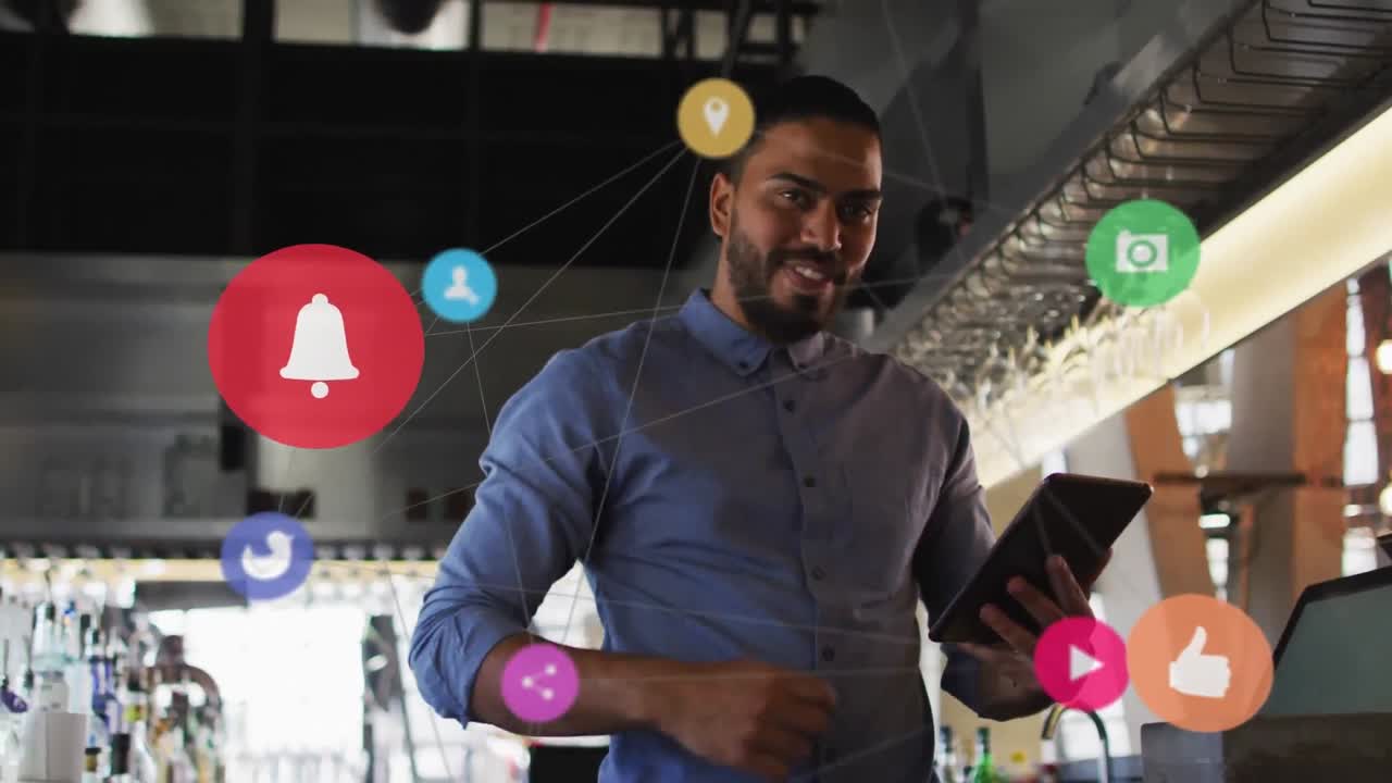 Animation of social media icons with network over biracial businessman using tablet