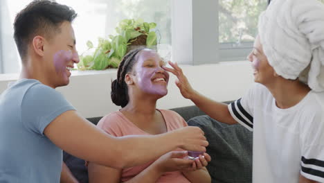 Un-Joven-Asiático-Y-Dos-Jóvenes-Birraciales-Disfrutan-De-Una-Divertida-Rutina-De-Cuidado-De-La-Piel-En-Casa