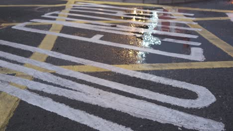 Winter-time-in-Kinsale-Ireland,-with-Christmas-lights-reflecting-in-a-puddle