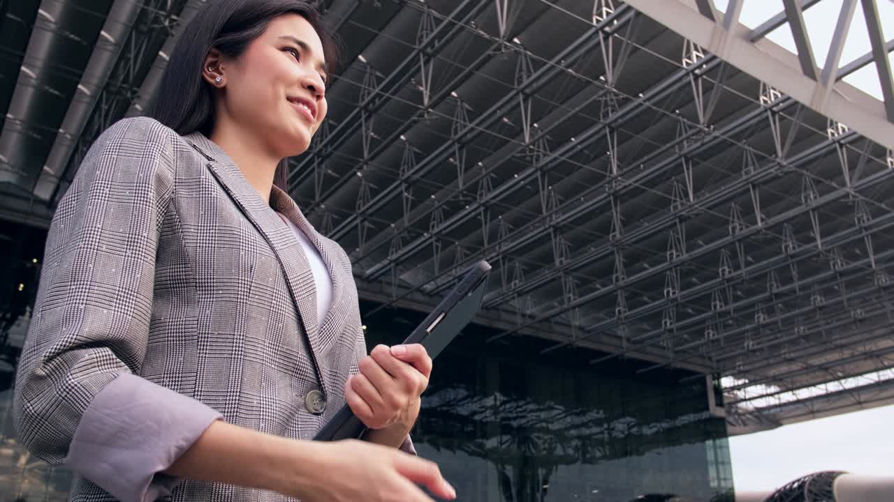 Asian man and woman in a suit, a businessman shaking hands with a woman colleague, a handshake in the office building outdoor.