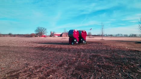 american farmers celebrating valentine's hay bale art in countryside