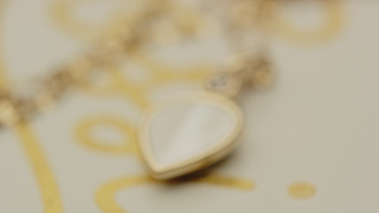 Extreme close up of a beautiful golden locket on a necklace slowly going into focus