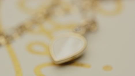 extreme close up of a beautiful golden locket on a necklace slowly going into focus