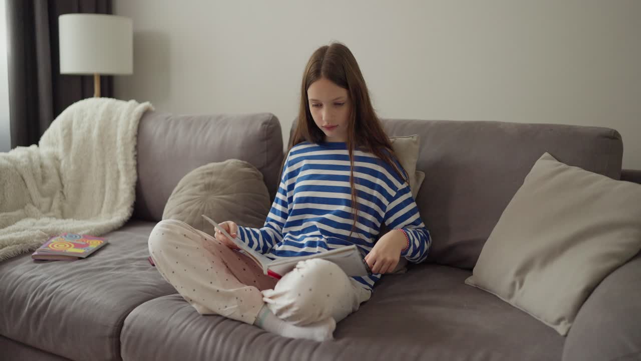 Ragazza che legge un libro sul divano