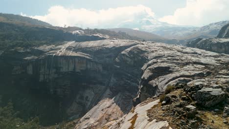 a stunning high-altitude rocky landscape with hualcán mountain rising above laguna 513 in peru's cordillera blanca - aerial flyover
