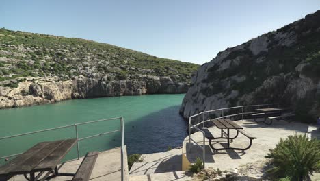 mesas vacías con asientos en la bahía magrr ix-xini en un día soleado en la isla de gozo