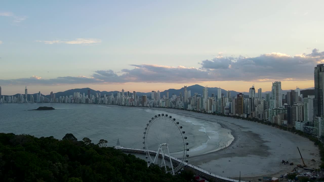 vista aérea de la ciudad de balneario camboriu al atardecer con la rueda de la fortuna y los edificios altos