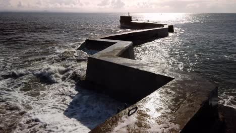 popular photographic location of the zig-zag breakwater pier in st monans, fife, scotland with storm waves breaking on a sunny day