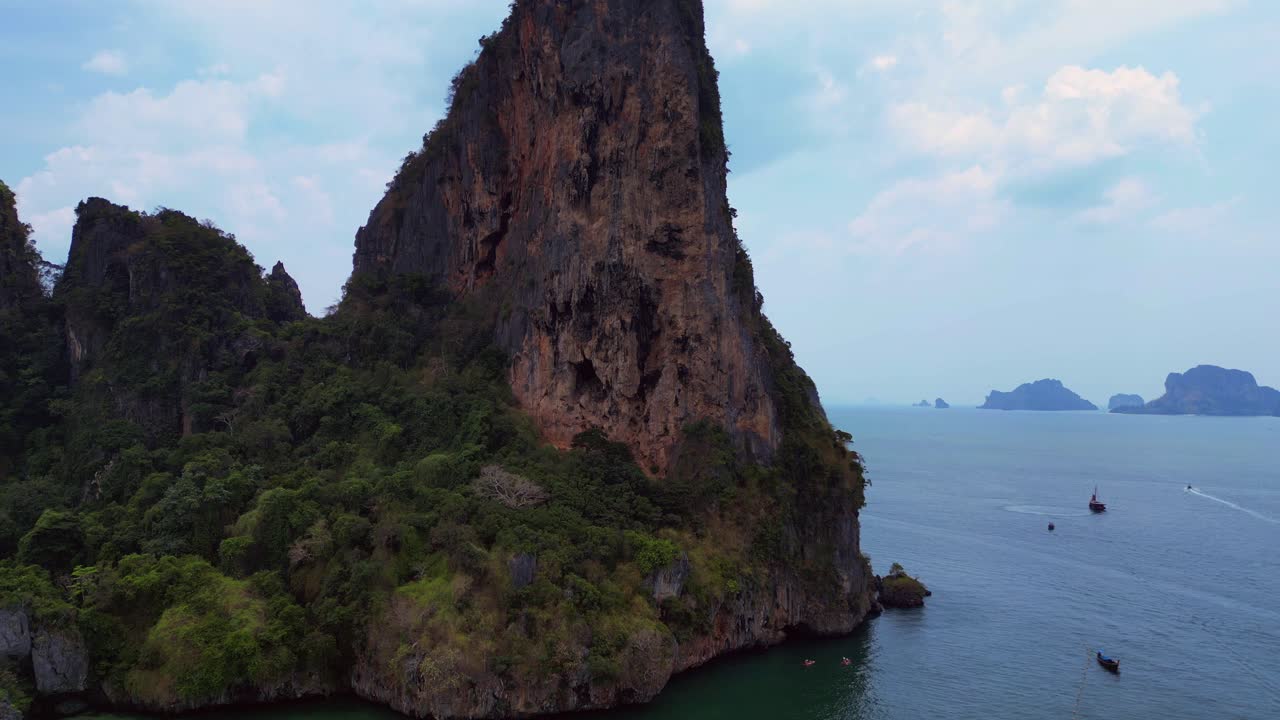 pensioner resting during a difficult Rock climb on Rai Leh beach cliff in Thailand. Best aerial view flight panorama overview drone