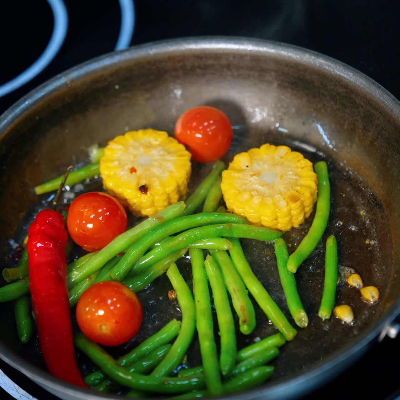 フライパンで野菜を調理。トウモロコシ、豆、唐辛子、トマトを一緒に炒める。縦画面。クローズアップ。