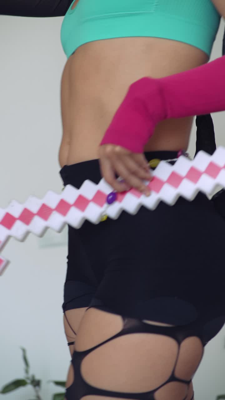 Giovane donna che balla giocosamente con una spada pixelata