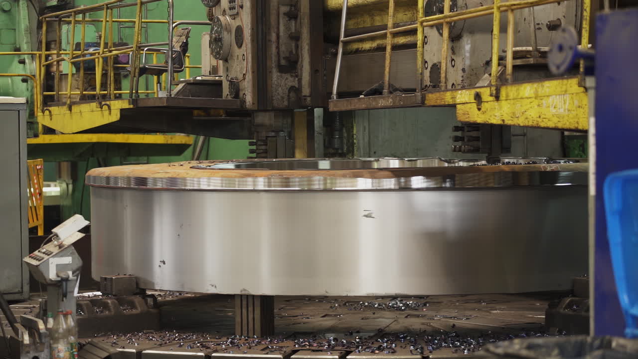 Large metal disk being machined on a heavy-duty lathe