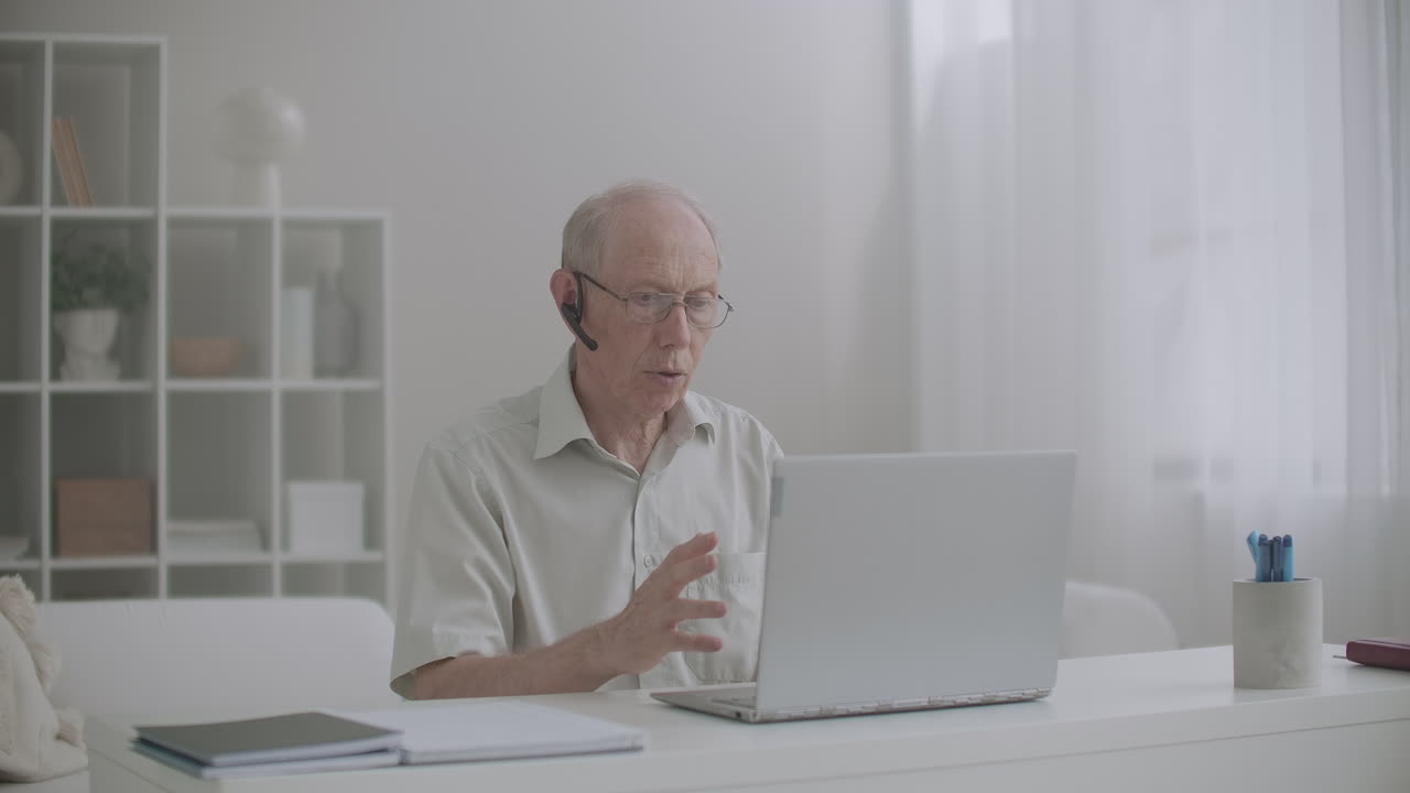 e-learning by internet aged man is lecturing sitting home in front of laptop communicating online