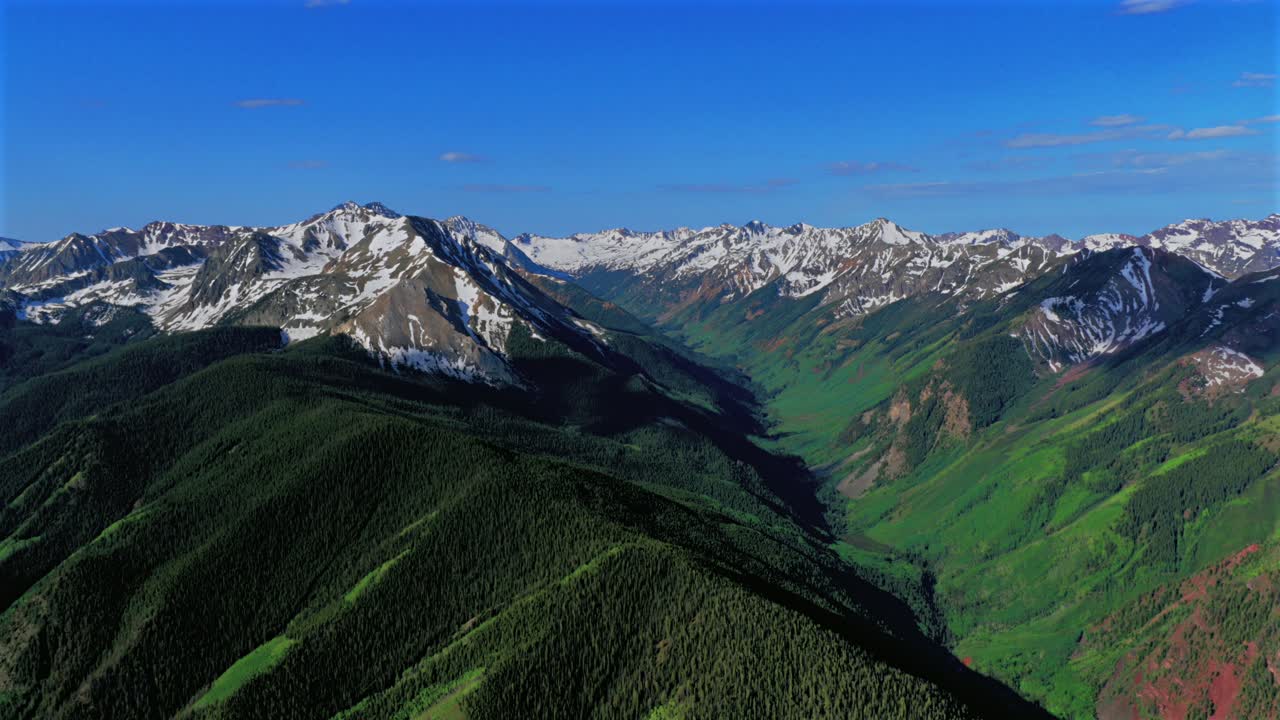 Castle Creek valley summit Conundrum Castle Peak Aspen Highlands bowl spring summer Maroon Bells Wilderness Pyramid Peak Elk Mountain Range aerial drone Colorado sunny morning blue sky clouds forward