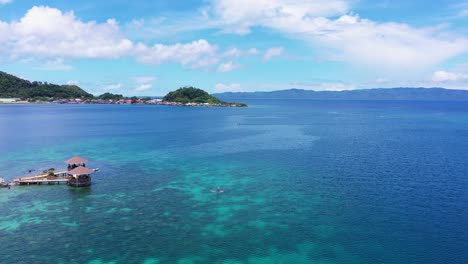 Panoramic-View-Of-The-Tourist-On-A-Paddle-Board-At-The-Shore-Of-Tagbak-Marine-Park-In-Leyte,-Philippines