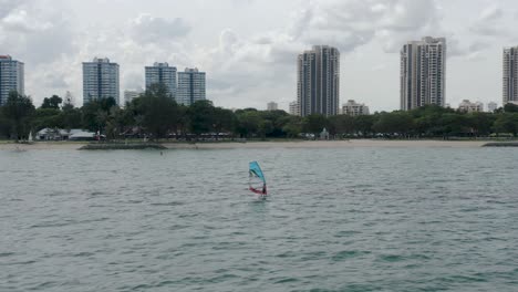 windsurfer windsurfing down the coast of singapore in east coast park (4k).mp4