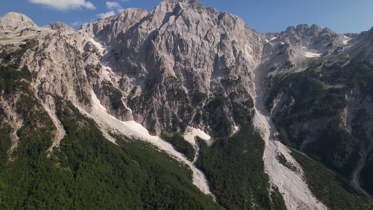 paisaje montañoso de cuento de hadas de picos alpinos rocosos cubiertos de nieve y silvicultura verde en albania