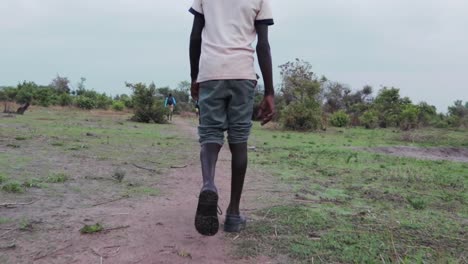 african child walking in refugee settlement to water source.