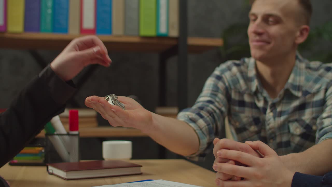 primer plano de una mujer agente de bienes raíces pasando la llave de la casa a un feliz propietario