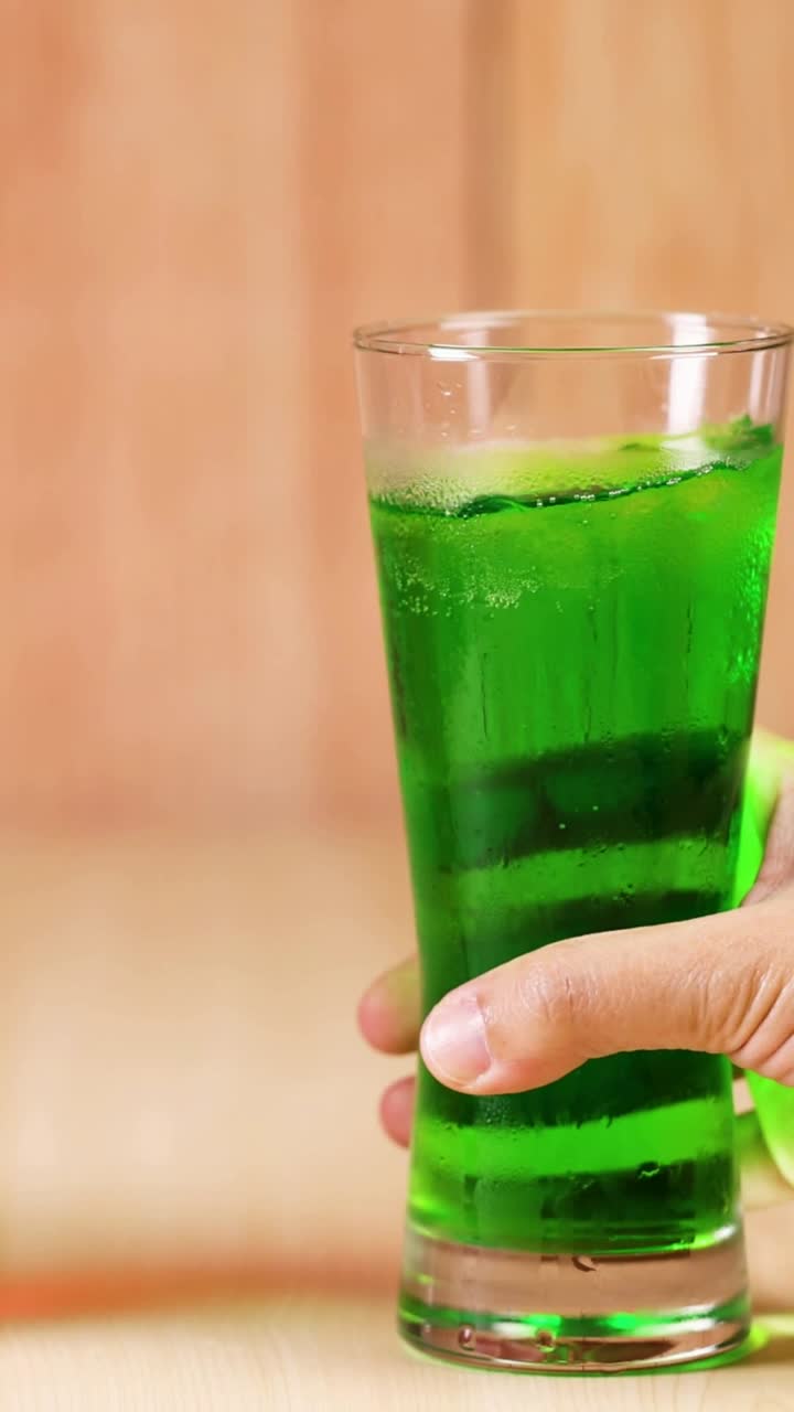 dos manos intercambiando bebidas rojas y verdes