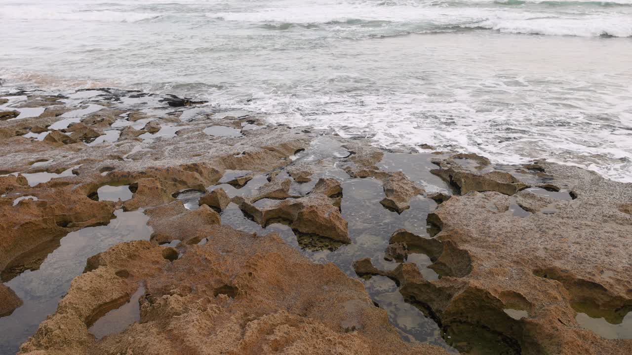 Onde oceaniche che si infrangono nelle pozze di roccia della penisola di Mornington