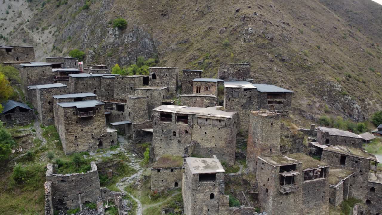 Tilted drone fly at Shatili ancient stone village environment with terraced and fortress-houses, Khevsureti, Mtskheta-Mtianeti, Georgia