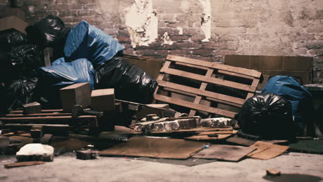 abandoned warehouse corner filled with garbage and discarded materials at dusk