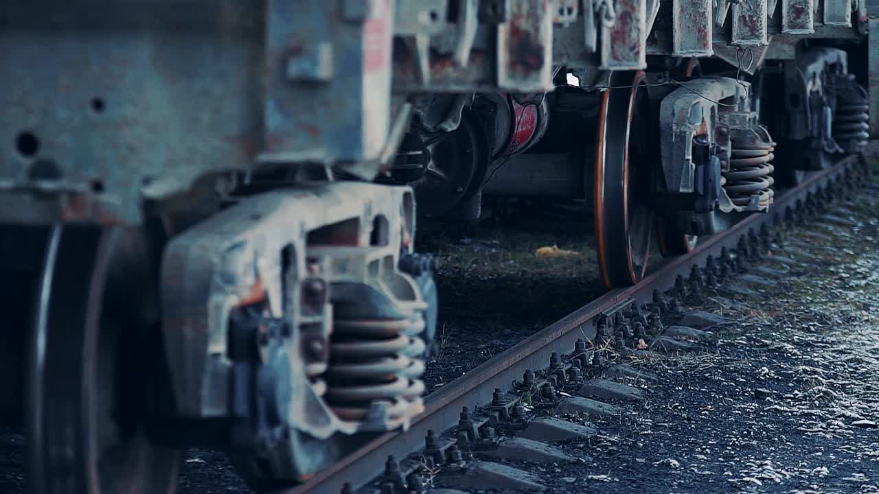 Ruedas de un vagón de tren de mercancías moviéndose a lo largo de un tramo de vía