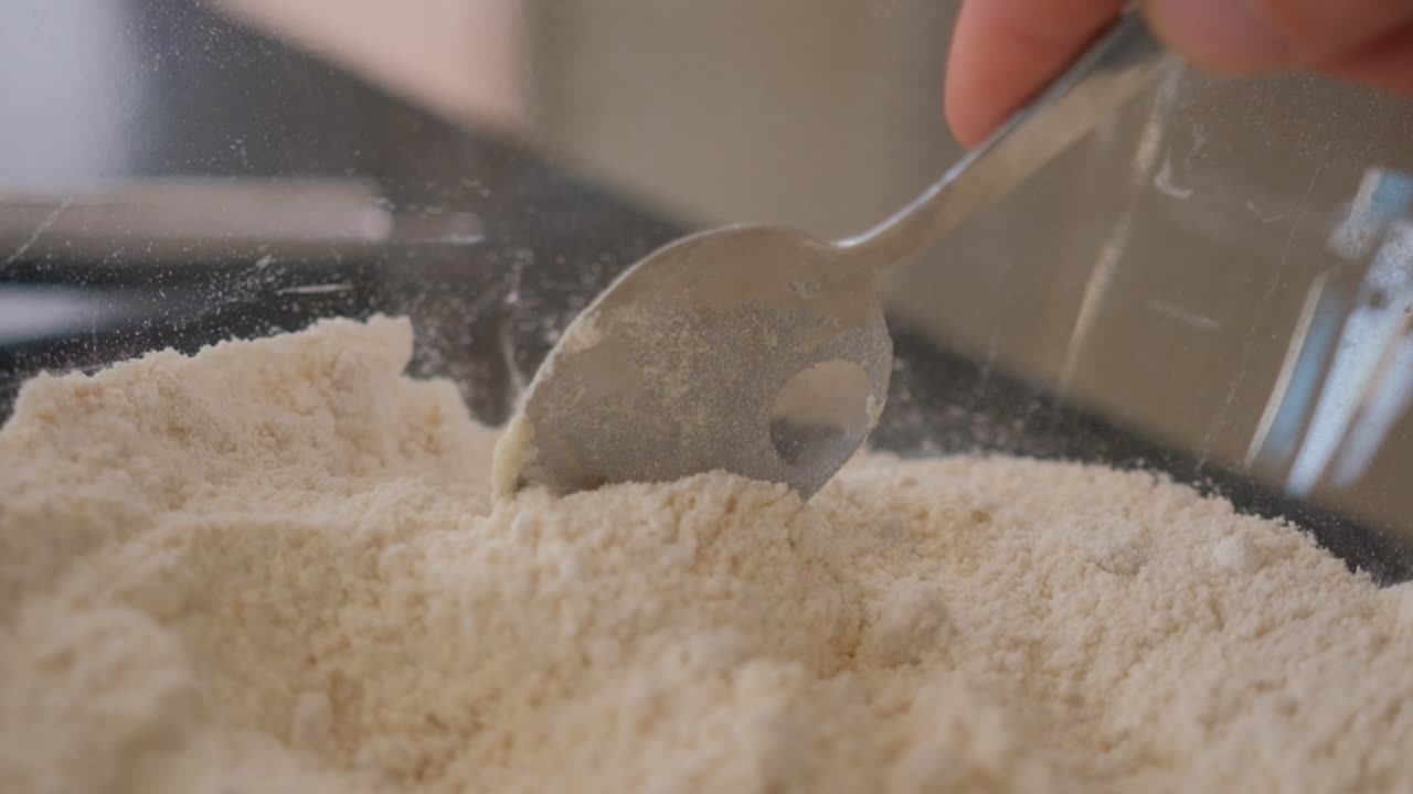 베이킹하는 동안 밀가루 한 그릇에 숟가락을 따라가는 슬로우 모션