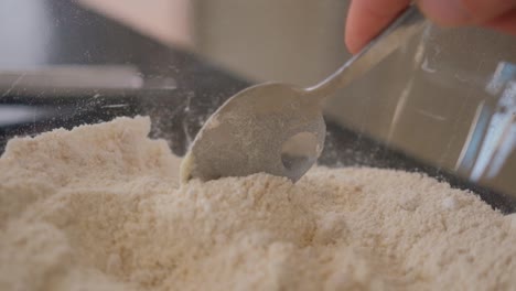 slow motion following a spoon in a bowl of flour while baking