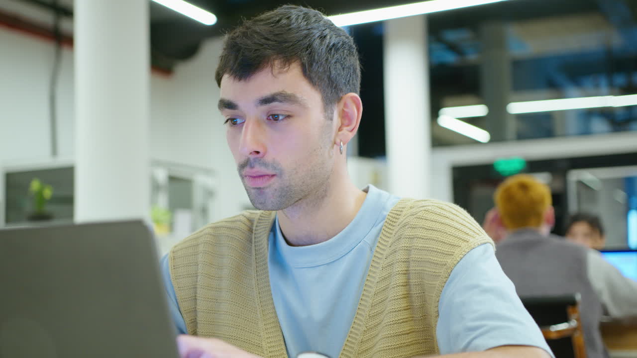 Young Handsome Man Typing on Laptop in the Office