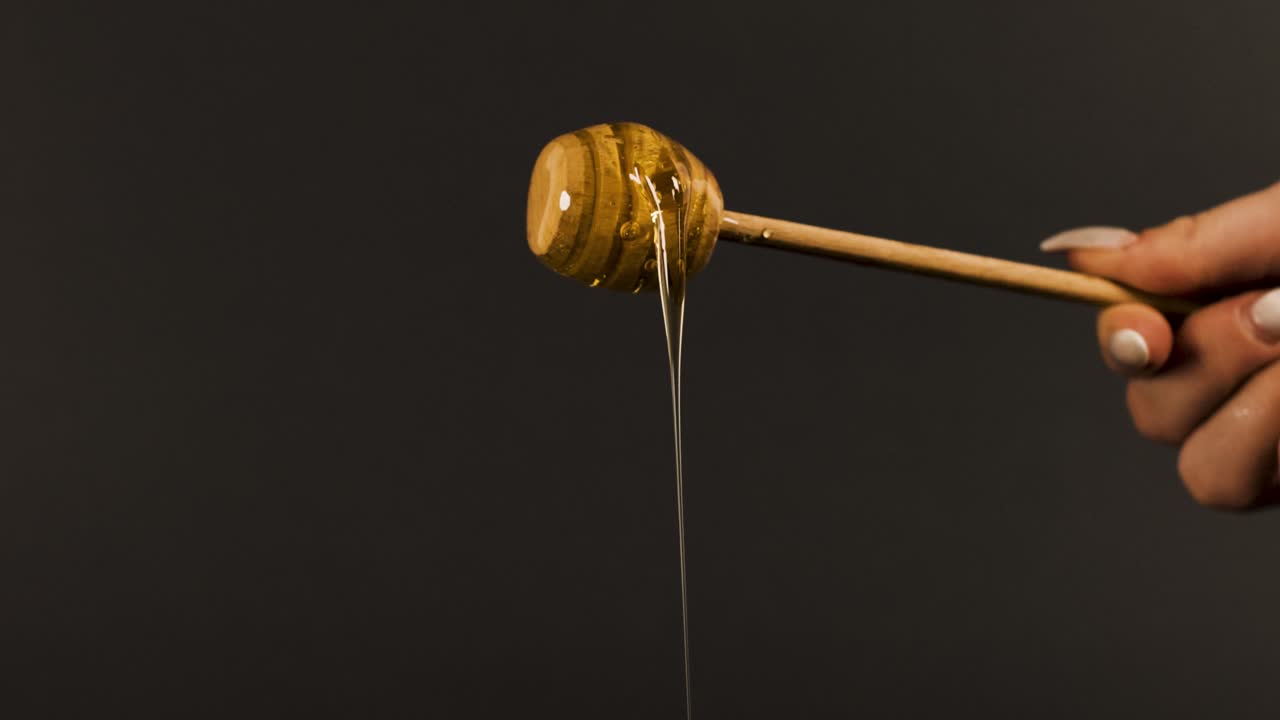 Honey slowly slipping from a honey dipper.