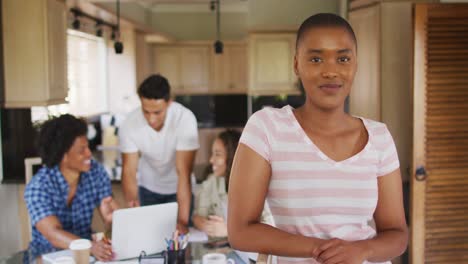 happy african american woman in kitchen with diverse friends working in background