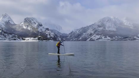 Mann-Auf-Paddelbrett-Zwischen-Wasser-Und-Bergen-An-Der-Küste