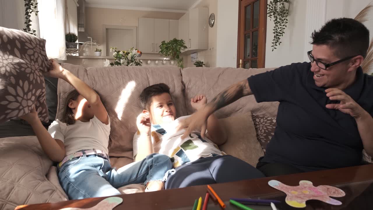 Playful mother joking with her kids in the sofa