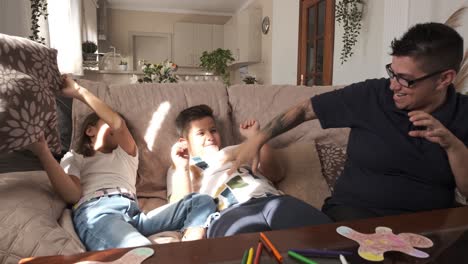 playful mother joking with her kids in the sofa