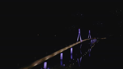 cable-stayed bridge lit up at night, aerial view