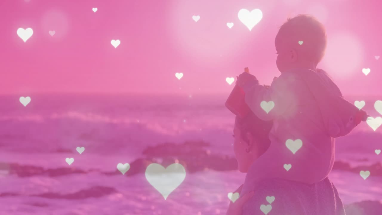 女性が水辺に到着し、赤ん坊を肩に担ぎ上げて健康を祈り、心臓が海の波の上で脈打っている。
