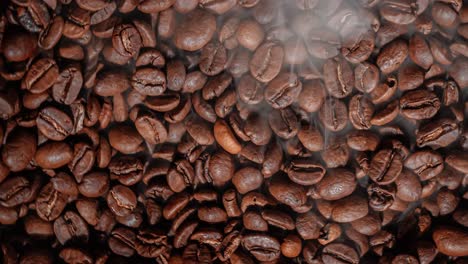 cerca de las semillas de café. los granos de café perfumados son tostados el humo viene de los granos de café.