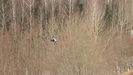 professional drone dji inspire 2 flies over the forest while blowing a strong wind