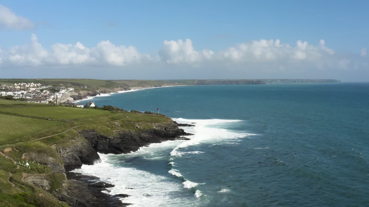 panorama aéreo de la playa de porthleven con olas espumosas y acantilados verdes en la costa de cornualles, reino unido
