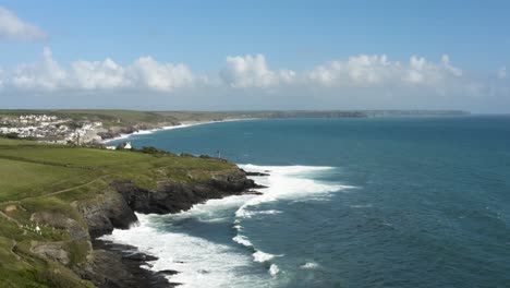 Panorama-Aéreo-De-La-Playa-De-Porthleven-Con-Olas-Espumosas-Y-Acantilados-Verdes-En-La-Costa-De-Cornualles,-Reino-Unido