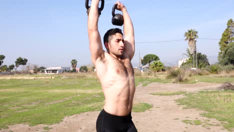 functional training with kettlebell outdoors and bare-chested