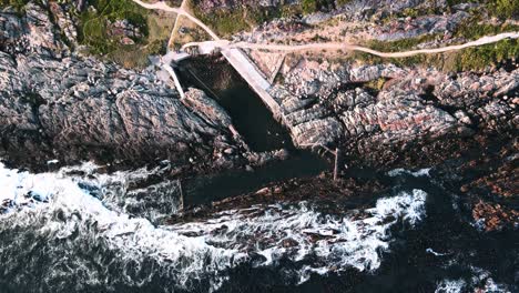 people swim in a cold water tidal pool on the south african coast