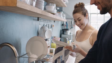 Newly-wed-in-love-couple-dancing-at-home-washing-dishes-wearing-pajamas-having-fun