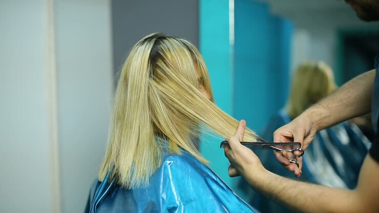 Parrucchiere che taglia i capelli. Stilista che taglia i capelli di una donna in un salone.
