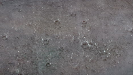 raindrops splashing in a puddle during a torrential rainstorm in monsoon season.